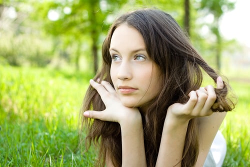 young woman thinking in the grass