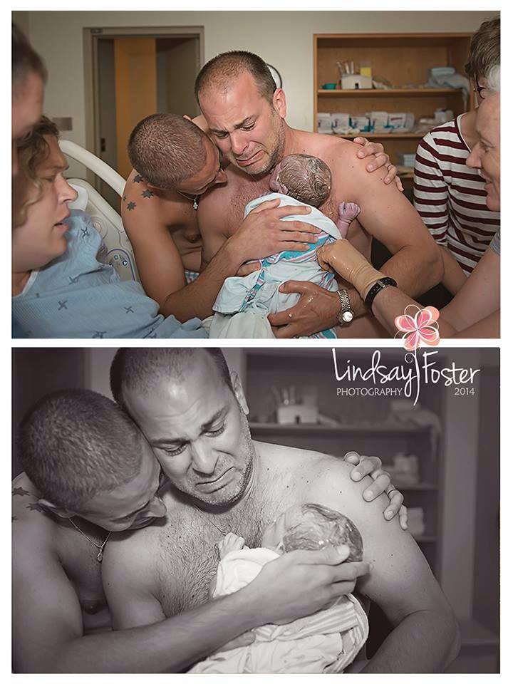 Two gay dads hold baby for the first time