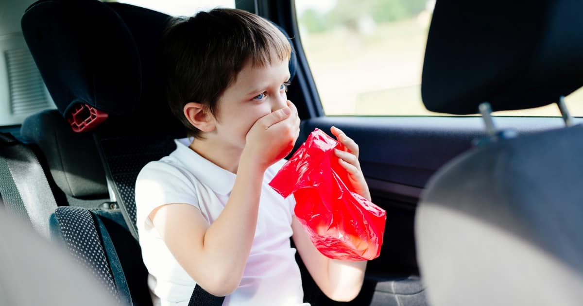 boy sick to his stomach in car